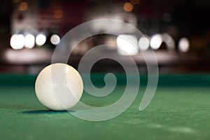 A white pool ball on a pool table.