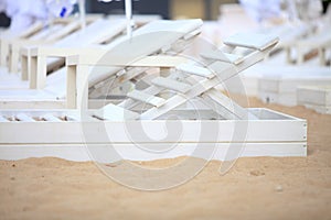 White pool chairs on sand beach