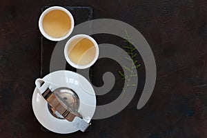 White porcelain Asian tea set with green tea Milk Oolong on black stone desk. Close up, top view