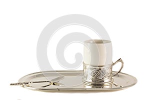 White porcelain coffee Cup with silver spoon on tray