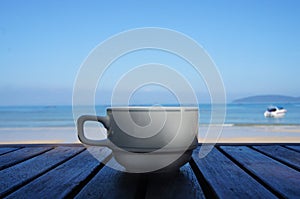 White porcelain cup of coffee on the sea background