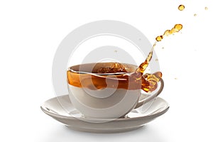 White porcelain cup with spilled tea, isolated on a white background