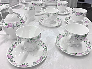 White porcelain dishes and cups stay on table