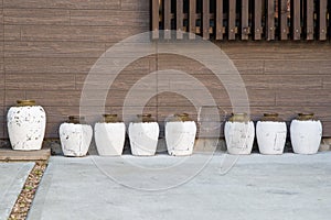 White porcelain jars next to faux wooden wall