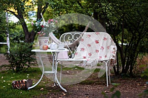 White porcelain set for tea or coffee on table in the garden over blur green nature background. Summer outdoor party