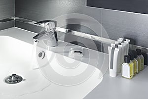 White porcelain sink with chrome faucet that releases water