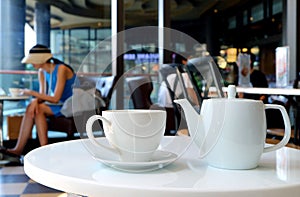 White porcelain tea set served on cafe`s round table