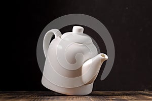 White porcelain teapot on a dark background