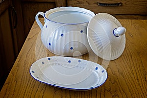 White porcelain tureen with patterned flowers on a wooden table