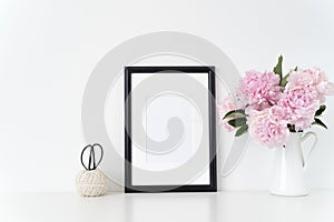 White portrait frame mock up with a pink peonies beside the frame, overlay your quote, promotion, headline, or design