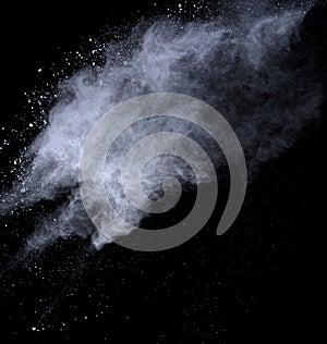 White powder explosion on black background. Dust splatted isolated. Paint Holi