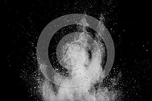 White powder explosion on black background. White dust particles splash