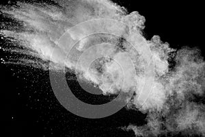 White powder explosion cloud against black background.