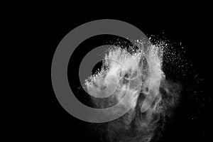 White powder explosion.Freeze motion of white dust particles on black background