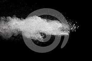 White powder explosion.Freeze motion of white dust particles on black background