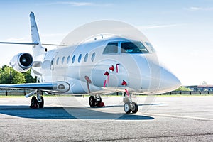 White private business jet at the parking lot of airport