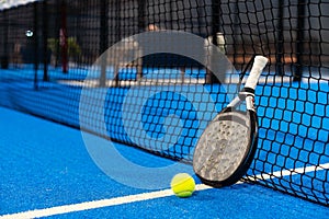White professional paddle tennis racket with natural lighting on blue background. Horizontal sport theme poster