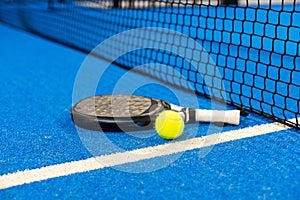 White professional paddle tennis racket with natural lighting on blue background. Horizontal sport theme poster