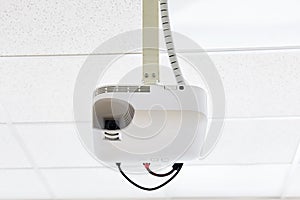White projector hanging on the ceiling