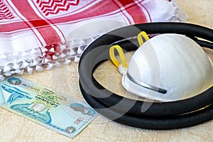 White Protective Mask, Dirham Banknote, and Traditional Arab Male Clothes - kaffiyah and agal  close-up photo