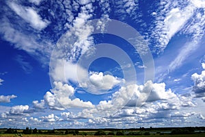 White puffy clouds in blue sky, agricultural landscape