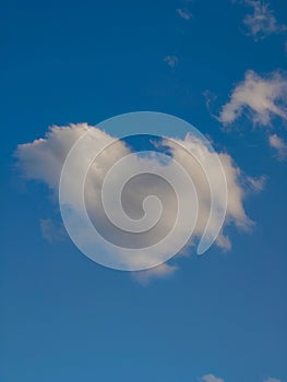 White puffy heart shaped cloud set against a deep blue summer sky