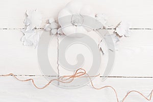 White pumpkin, berries and leaves and white sheet of paper and linen rope on a wooden mockup autumn background. Greeting photo