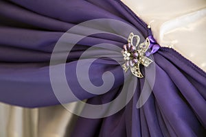 White and purple drapes with brooches