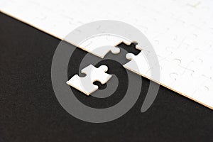 White puzzle with missing piece on black background. Business concept. Finish what you start. Team work and partnership.