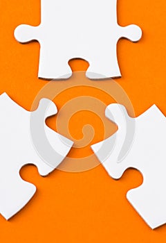 White puzzle parts on orange background