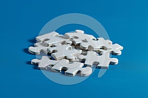 White Puzzle Pieces Clustered on Blue Surface