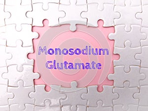 White puzzle with the word Monosodium Glutamate on a pink background