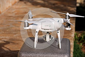 White quadcopter Drone with 4K digital camera on stand is ready for take off to fly in air to take photos, record footage.