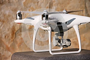 White quadcopter Drone with 4K digital camera on stand is ready for take off to fly in air to take photos, record footage.