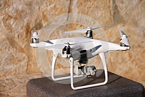 White quadcopter Drone with 4K digital camera on stand is ready for take off to fly in air to take photos, record footage.