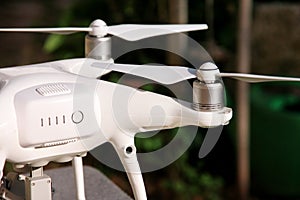 White quadcopter Drone with 4K digital camera on stand is ready for take off to fly in air to take photos, record footage.