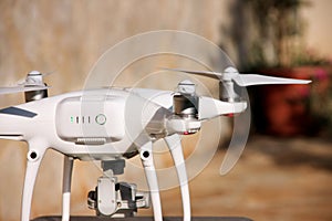 White quadcopter Drone with 4K digital camera on stand is ready for take off to fly in air to take photos, record footage.