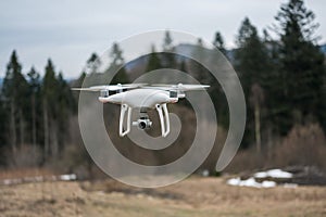 White Quadrocopter flying in forest