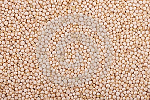 White quinoa seeds background. Pile of raw kinwa. Top view.