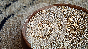 White quinoa seeds on a black background. quinoa in bowl on kitchen table top view. Healthy and diet superfood product.