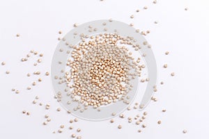 White quinoa seeds scattered on white background