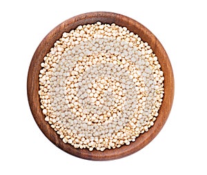 White quinoa seeds in wooden bowl, isolated on white background. Pile of raw kinwa. Top view.