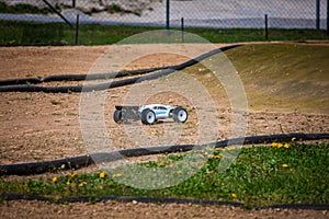 White Radio Controlled RC Offroad Truggy on an outdoor track training during sunny day