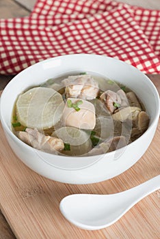White radish chicken soup in white bowl.