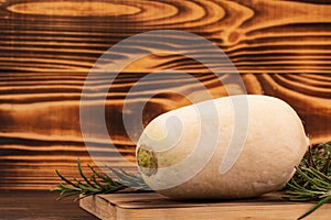 White radish and rosemary twigs on wooden cutting board