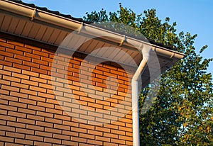 White rain gutter on the roof the brick building