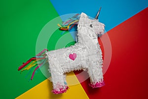 White and rainbow unicorn piÃ±ata, colorful background