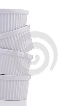 White ramekin dishes very unstable stack close-up isolated on white photo