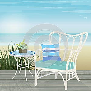 White rattan chair and mosaic table on a deck by the beach