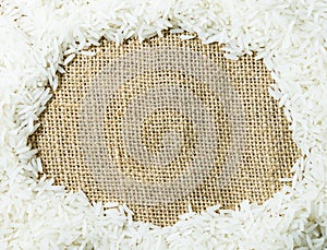 White raw Thai jasmine rice on gunny sack cloth texture